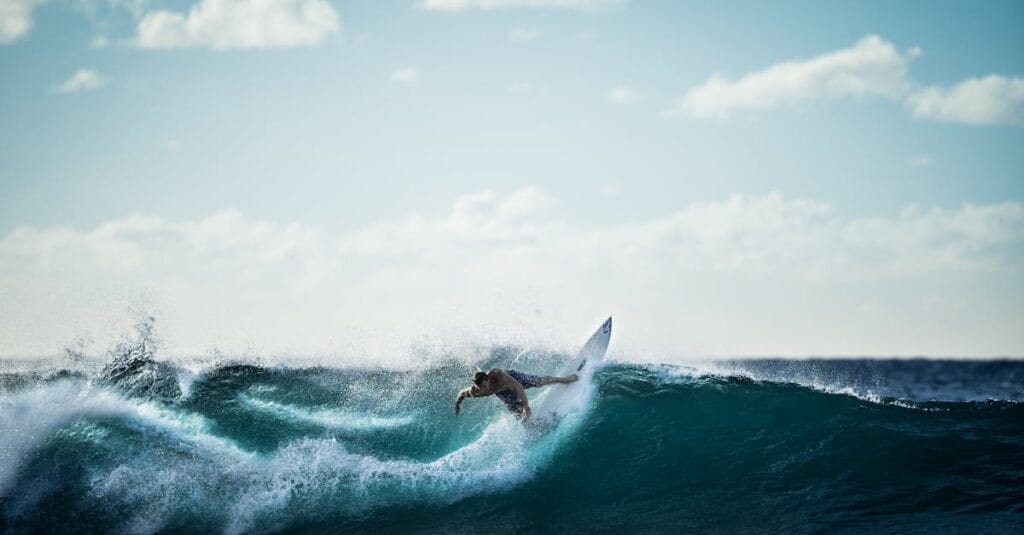 Thrilling action shot of a surfer riding the waves under a clear sky.